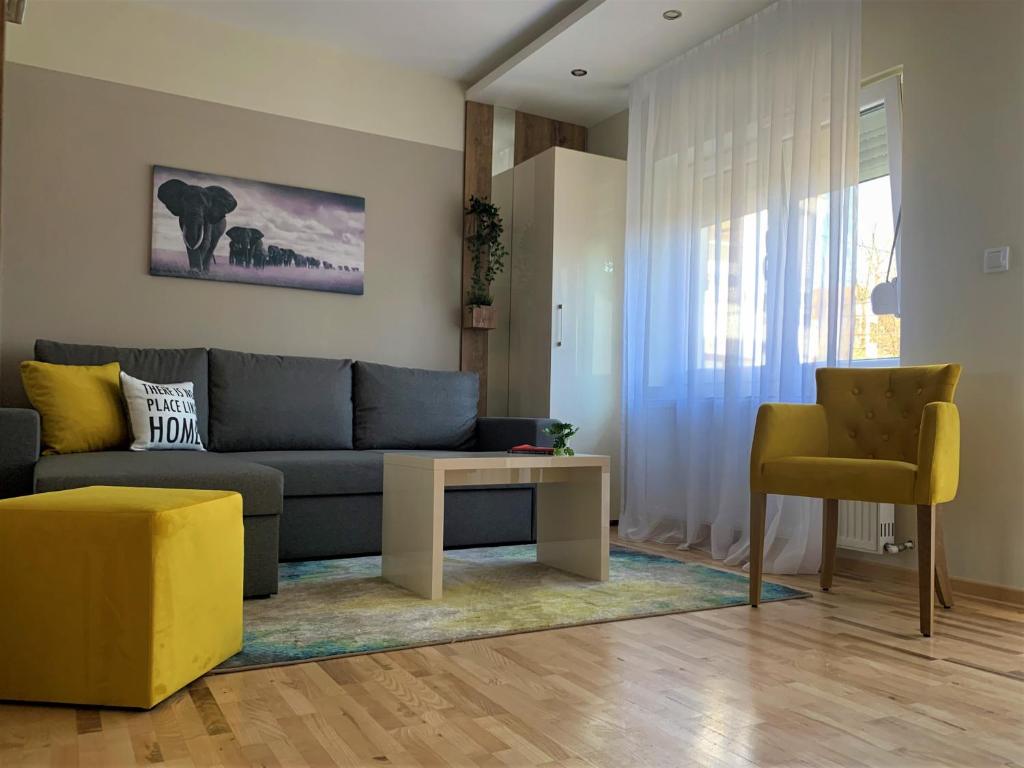 a living room with a blue couch and a yellow chair at Vip House 2 in Vrnjačka Banja