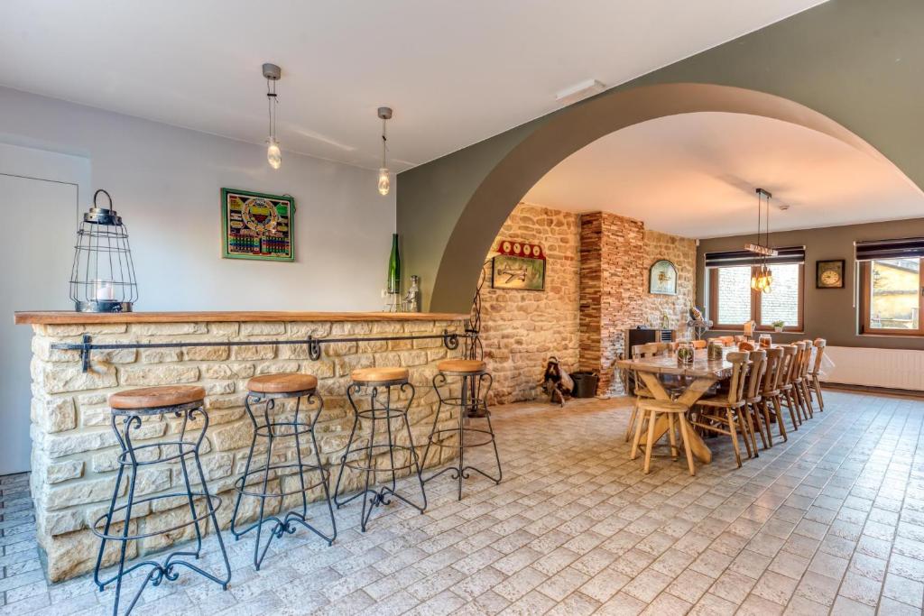Zimmer mit einer Steinmauer und einer Bar mit Hockern in der Unterkunft Gîte de la cascade in Villers-devant-Orval