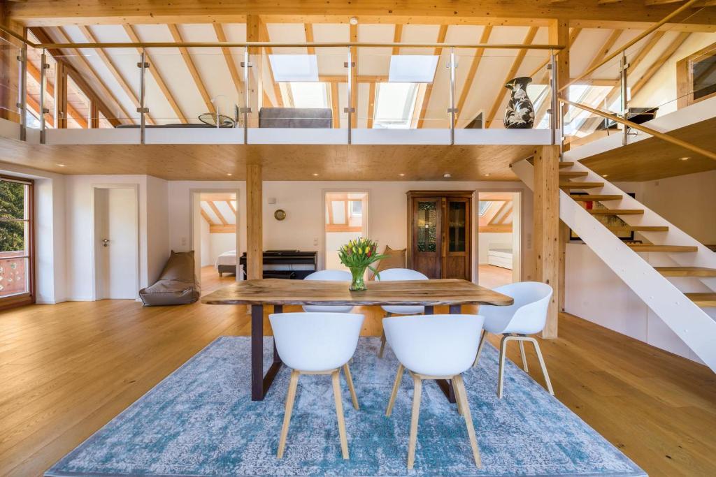 a dining room with a wooden table and white chairs at Maisonettewohnung am Wössener See in Unterwössen