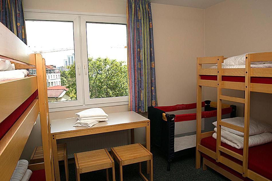 a dorm room with bunk beds and a window at CVJM Jugendgästehaus Berlin in Berlin