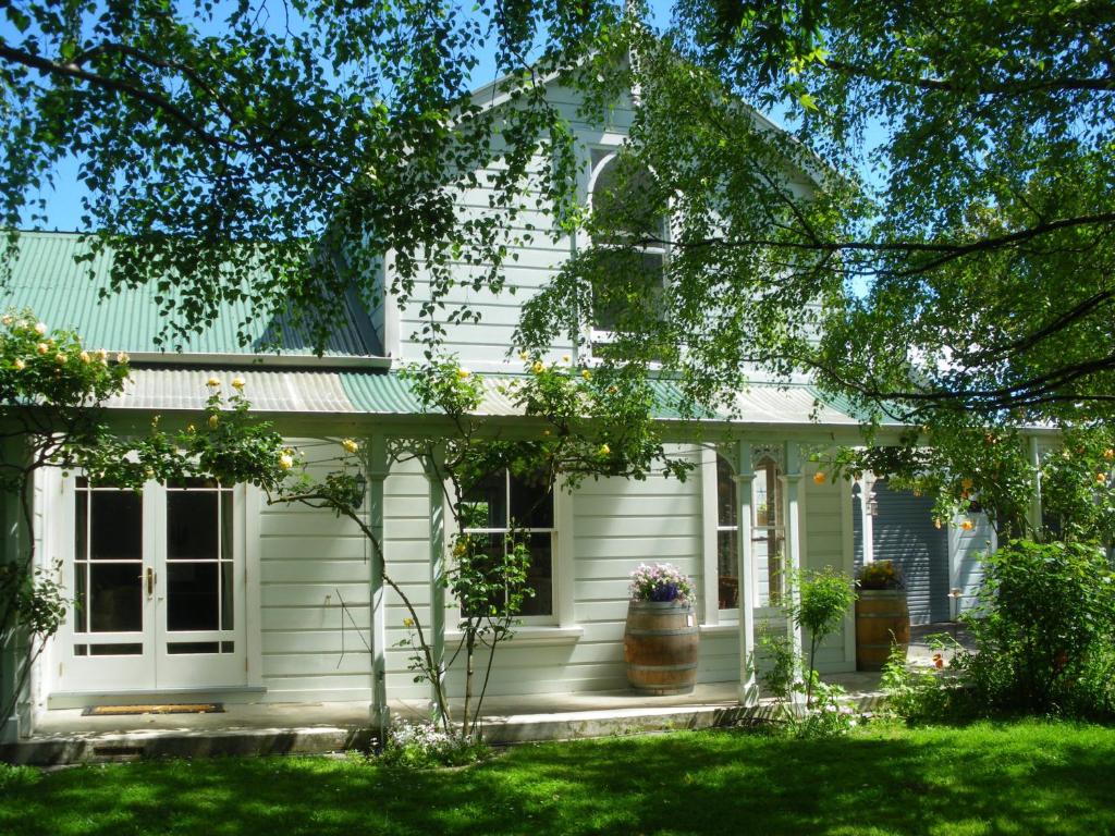 uma casa branca com um telhado verde em The Saddlery em Greytown