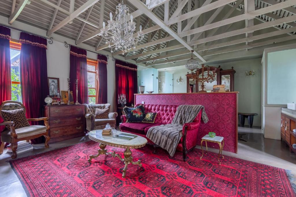 a living room with a red couch and a red rug at Festina Lente Guesthouse in Johannesburg