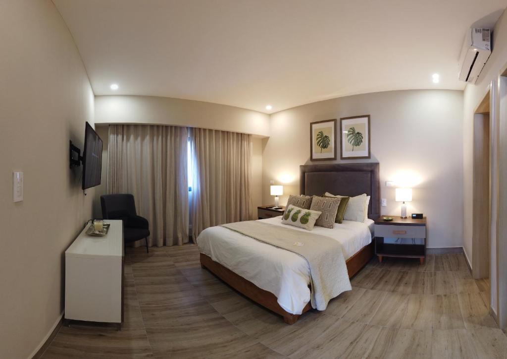 a hotel room with a large bed and a desk at Regatta Living Hotel By Mint in Santo Domingo