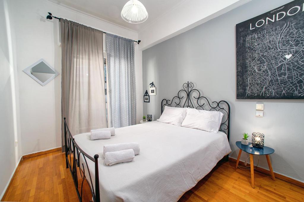 1 dormitorio con 1 cama grande y 1 mesa en Acropolis Area Flat, en Atenas