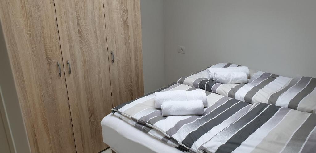 een bed met twee kussens naast een kast bij White Apartment in Izola