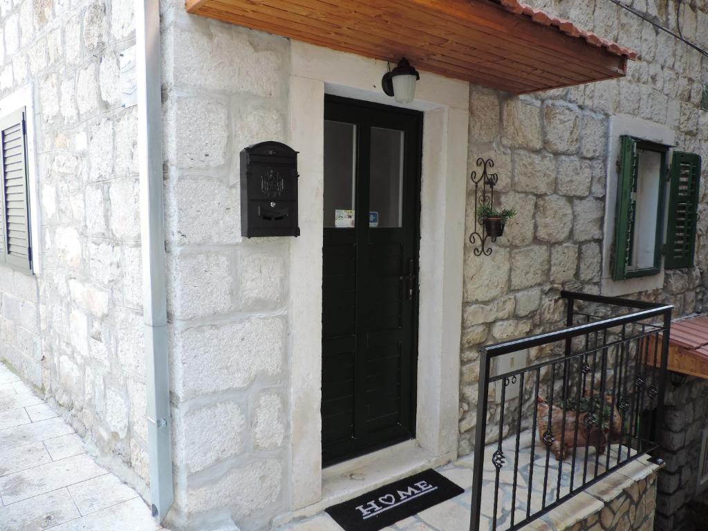 a black door on the side of a stone building at Apartments Lana in Split