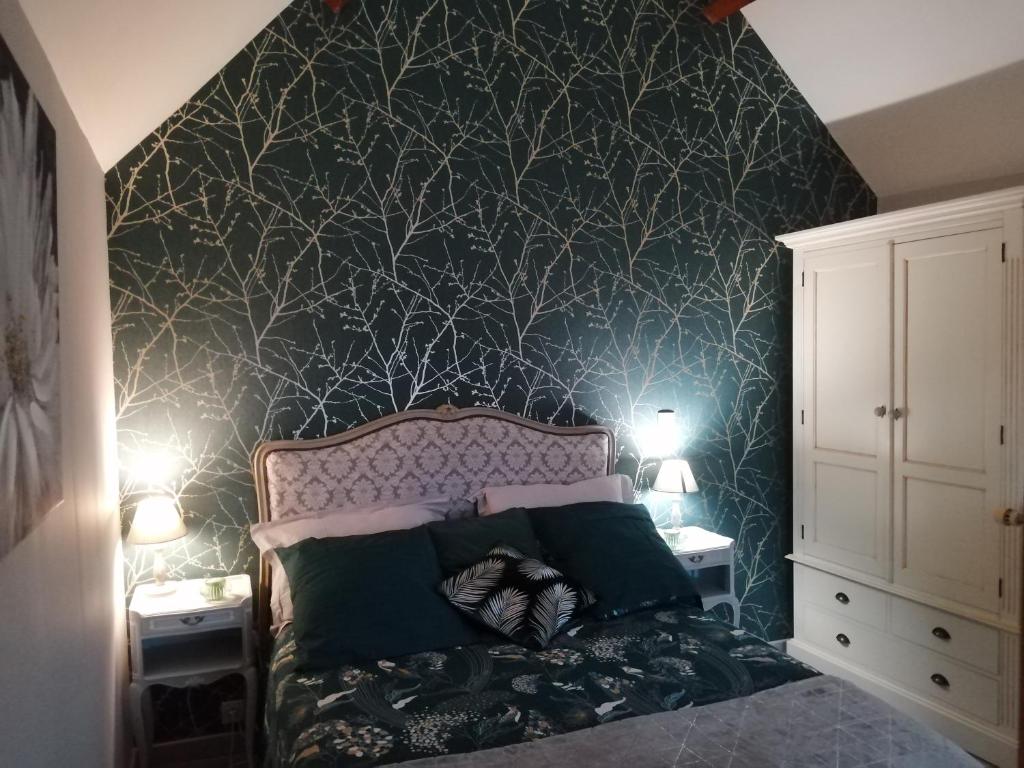 a bedroom with a bed with a green wall at Le clos des augers. Chambre Descartes in Azay-sur-Cher