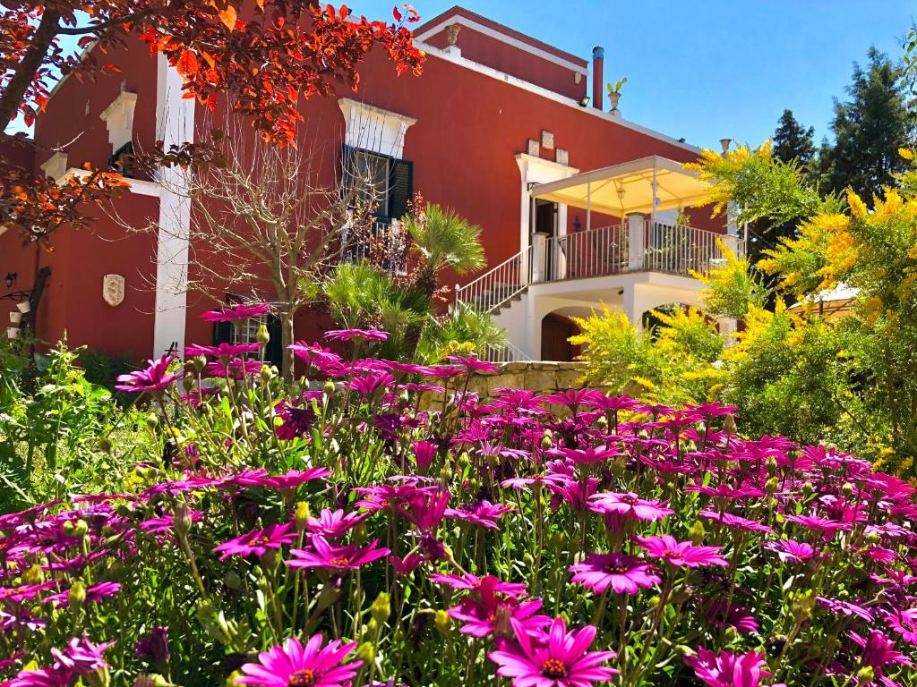 a garden with pink flowers in front of a house at Antica Masseria in Padresergio