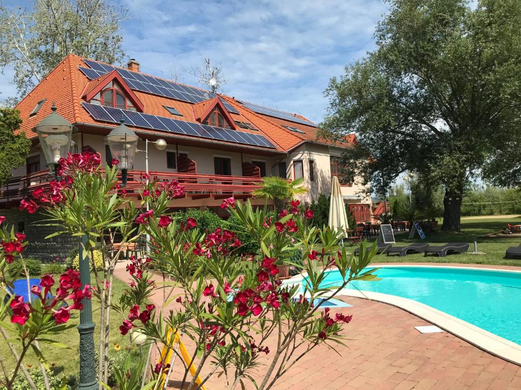 a house with a swimming pool in front of it at Zsanett Hotel in Balatonkeresztúr