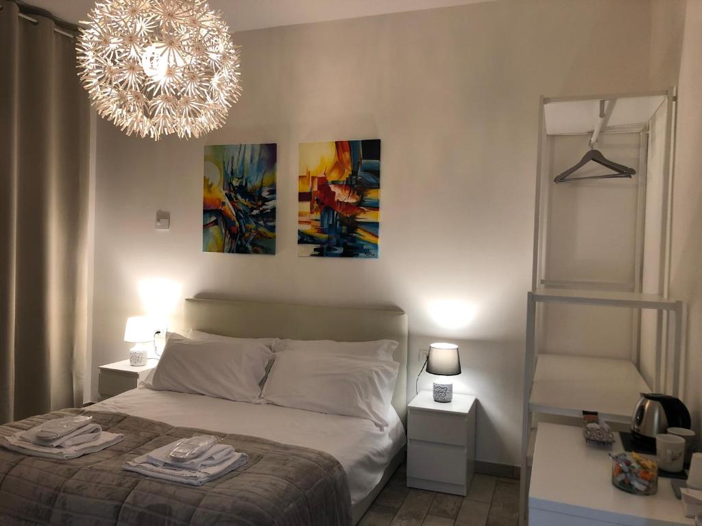 um quarto com uma cama e um lustre em Camere AME' em Peschiera del Garda