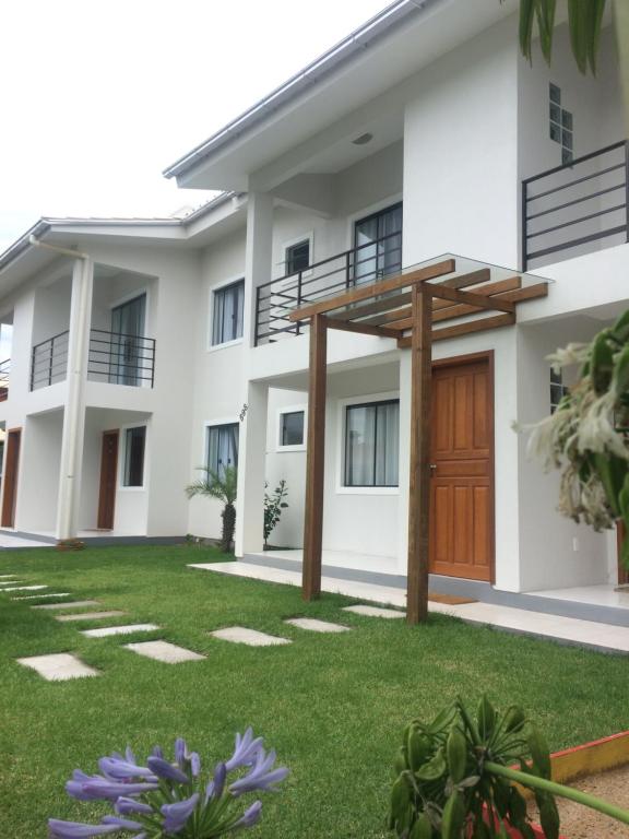 a house with a lawn in front of it at Residencial COLIBRI in Garopaba