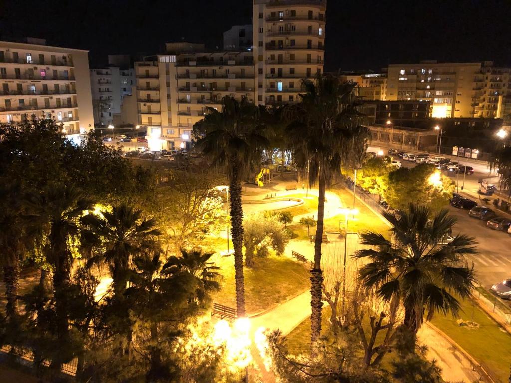 una ciudad de noche con palmeras y luces en AliceA apartment in Siracusa, en Siracusa