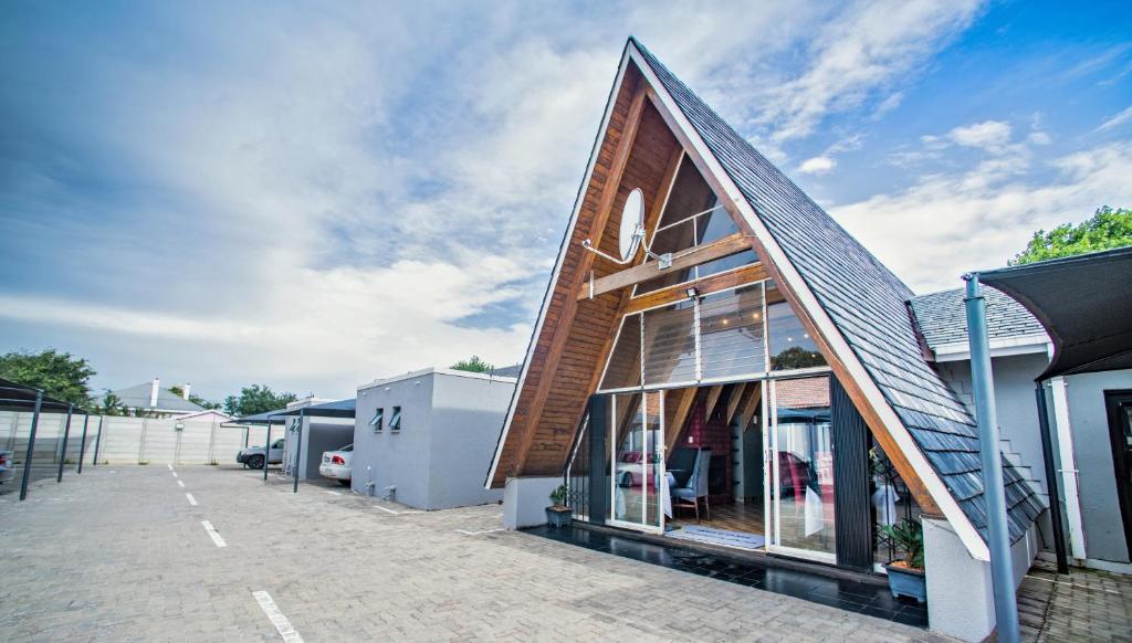 a building with a gambrel roof with glass windows at Khayalami Hotel - Standerton in Standerton