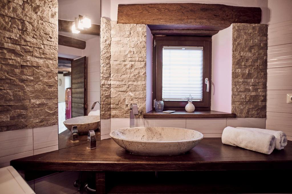 a large bathroom with two sinks and a window at Tmbin's barn - nature, horses, family in Sežana