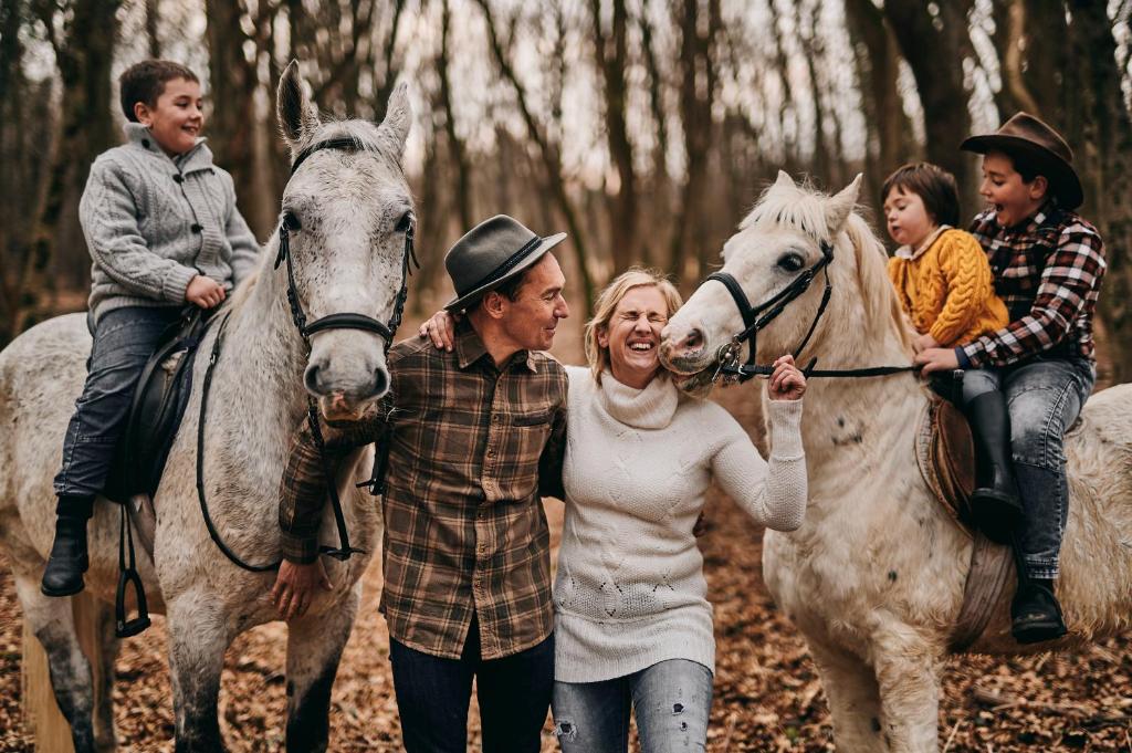 un grupo de personas montando a caballo en el bosque en Tmbin's barn - nature, horses, family, en Sežana