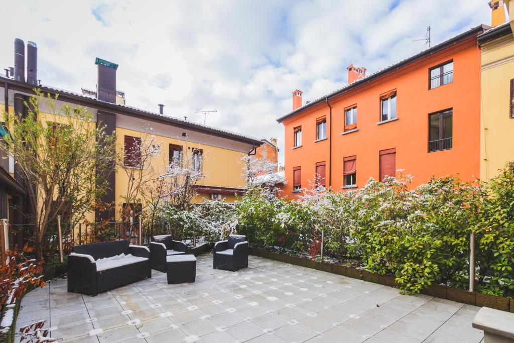 dziedziniec z kanapami przed niektórymi budynkami w obiekcie GetTheKey S.Felice Suites w Bolonii