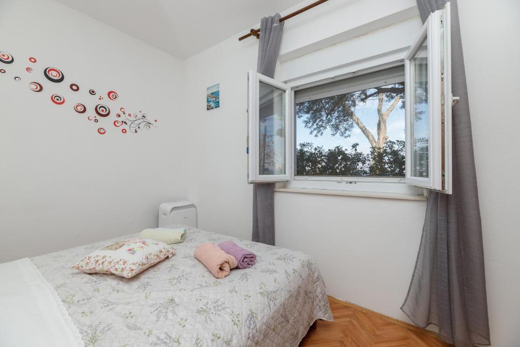 a bedroom with a bed and a window at Apartman Pandula in Tkon