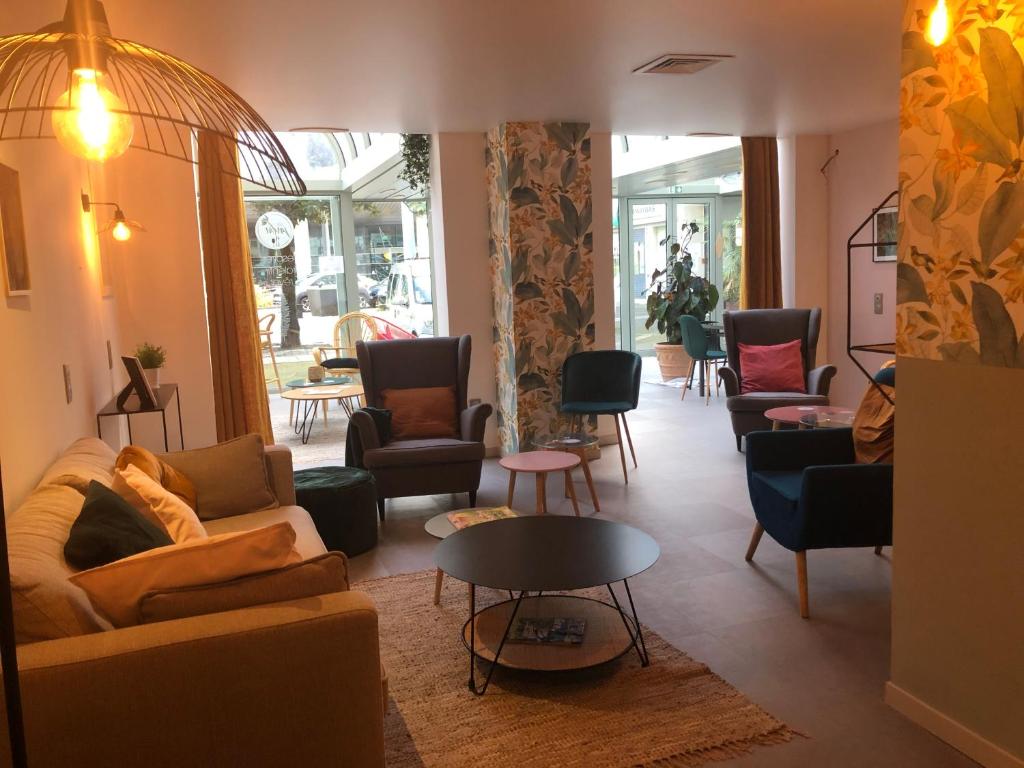 sala de estar con sofás, sillas y mesa en Hotel Europole, en Grenoble