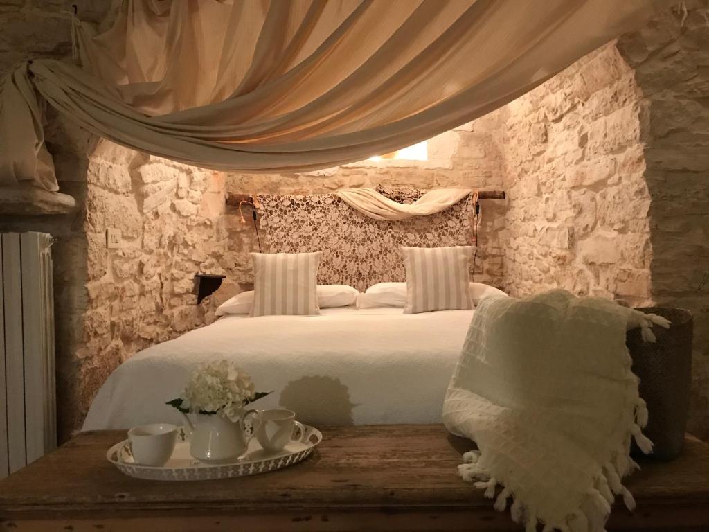 Un dormitorio con una cama blanca y una mesa con tazas en Trulli Aria di Casa, en Alberobello