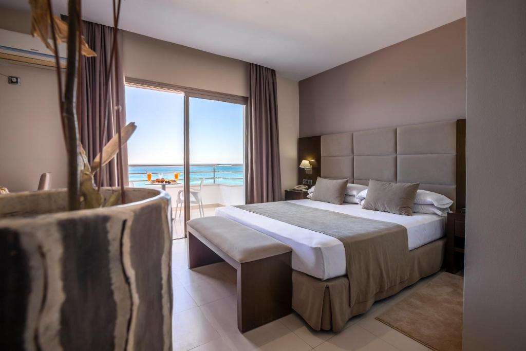 Cette chambre d'hôtel comprend un lit et offre une vue sur l'océan. dans l'établissement Suites Hotel Omeya, à Martil