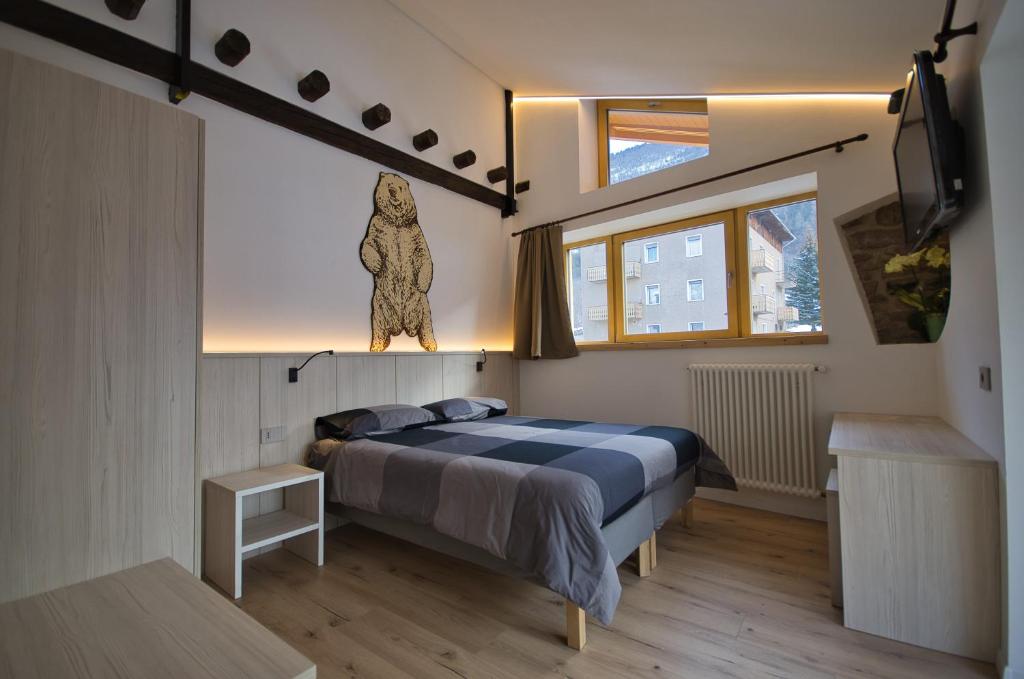 um quarto com uma cama com uma estátua de um urso na parede em B&B Paganella Flabbi's Family em Spormaggiore