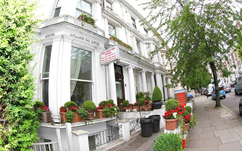 a white building with potted plants in front of it at Holland Inn Hotel in London