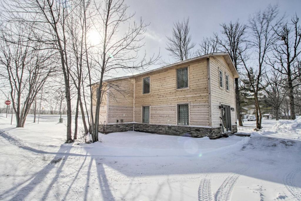 Remote Retreat Cozy Home with Big Pine Lake Access! في Perham: منزل خشبي صغير في الثلج مع الاشجار