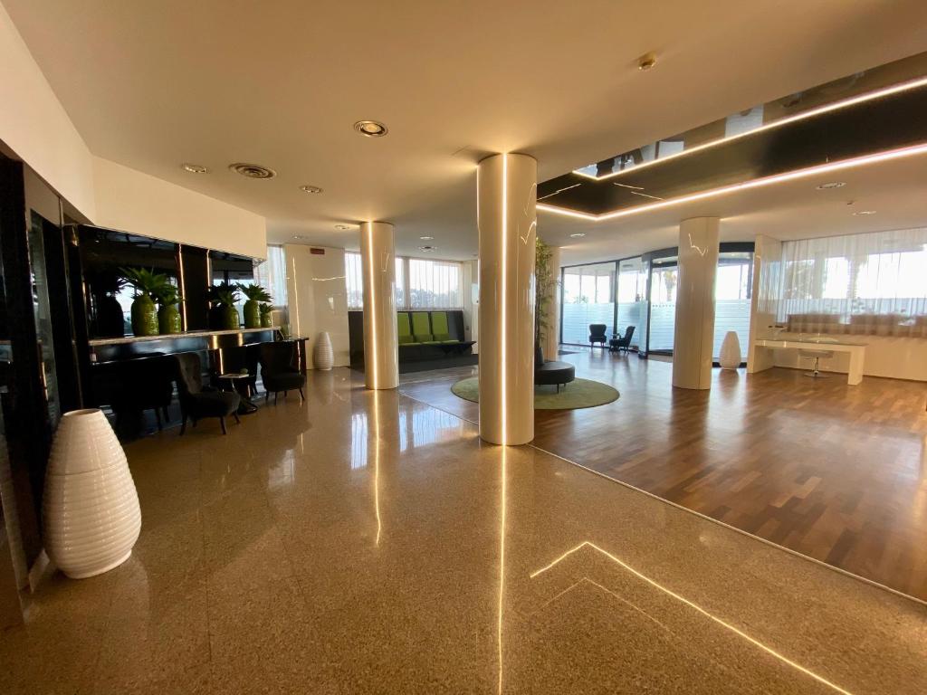 a large lobby with a table and chairs in a building at Barion Hotel & Congressi in Bari