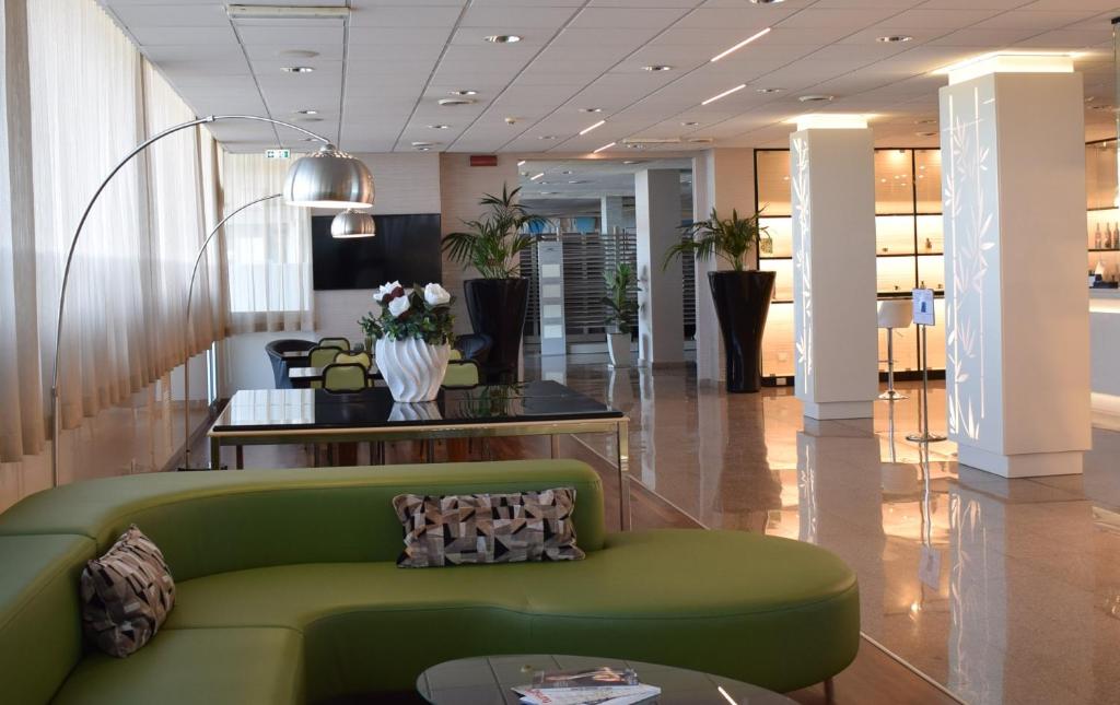 a living room with a green couch and a table at Barion Hotel & Congressi in Bari