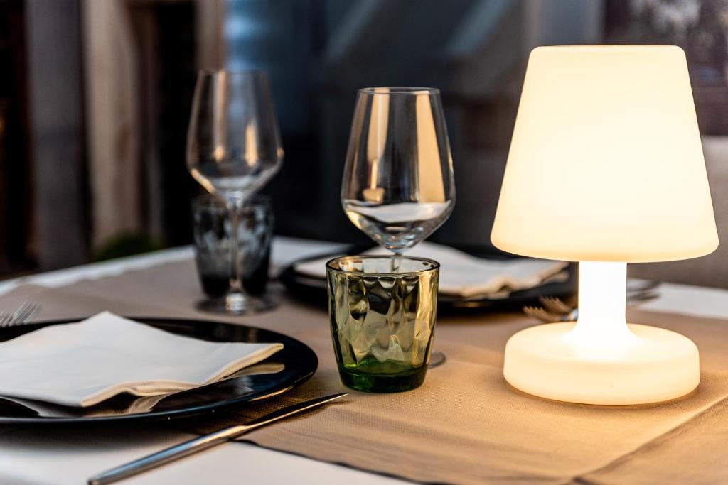 a table with two wine glasses and a lamp on it at Barion Hotel & Congressi in Bari