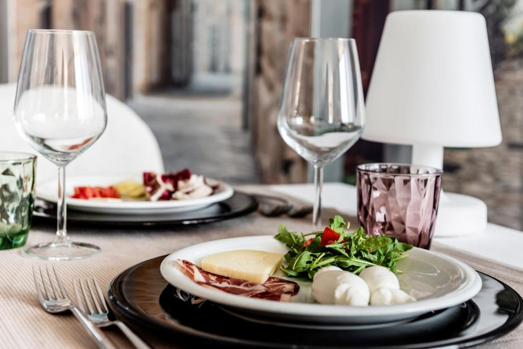 a table with two plates of food and wine glasses at Barion Hotel & Congressi in Bari