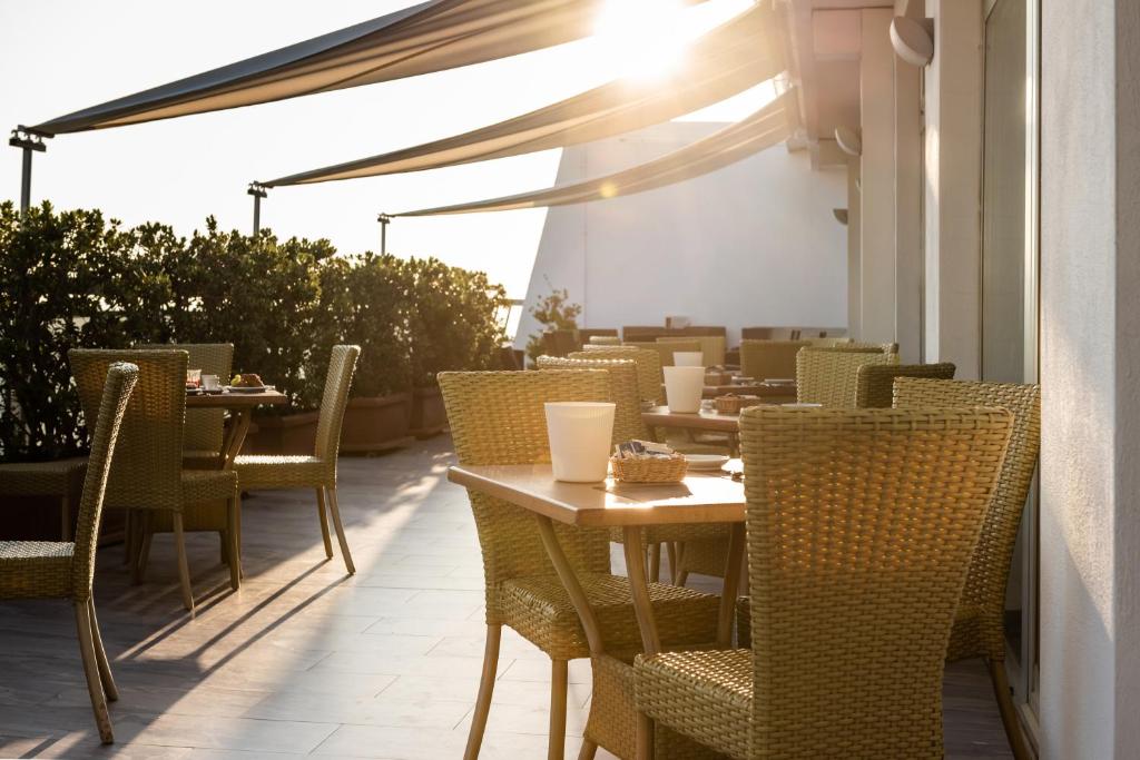 a restaurant with tables and chairs on a patio at Barion Hotel & Congressi in Bari
