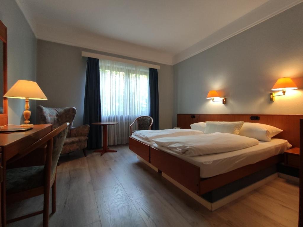 Habitación de hotel con cama, escritorio y escritorio. en Condi Hotel en Hamburgo
