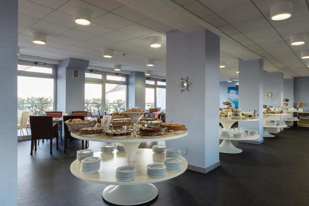 a cafeteria with white tables with food on them at Barion Hotel & Congressi in Bari