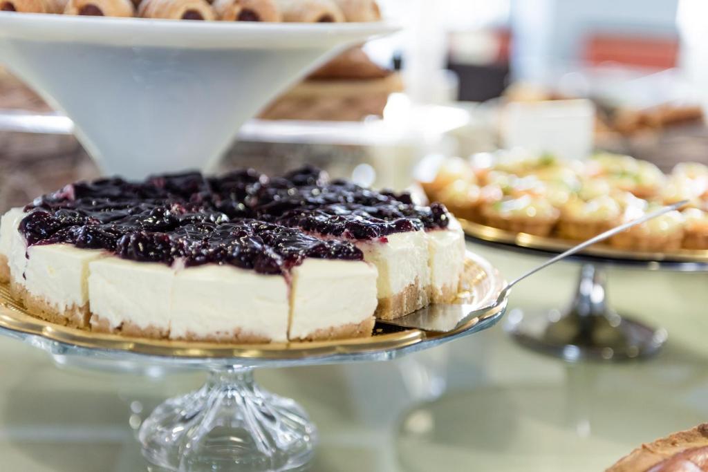 a blueberry cheesecake on a plate on a table at Barion Hotel & Congressi in Bari