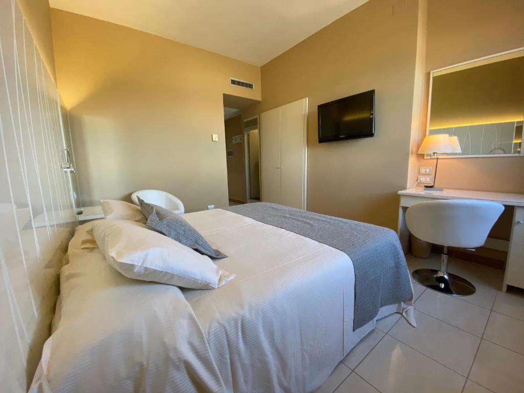 a bedroom with a large white bed with pillows at Barion Hotel & Congressi in Bari