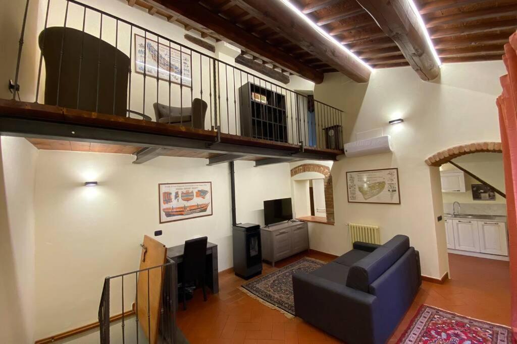 sala de estar con sofá azul y TV en Le Casette di Viola, en Arezzo