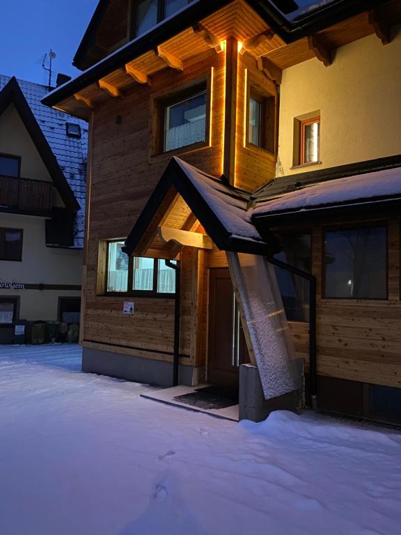 una casa con la neve sul davanti di Apartamenty pokoje Nad Potokiem a Zakopane