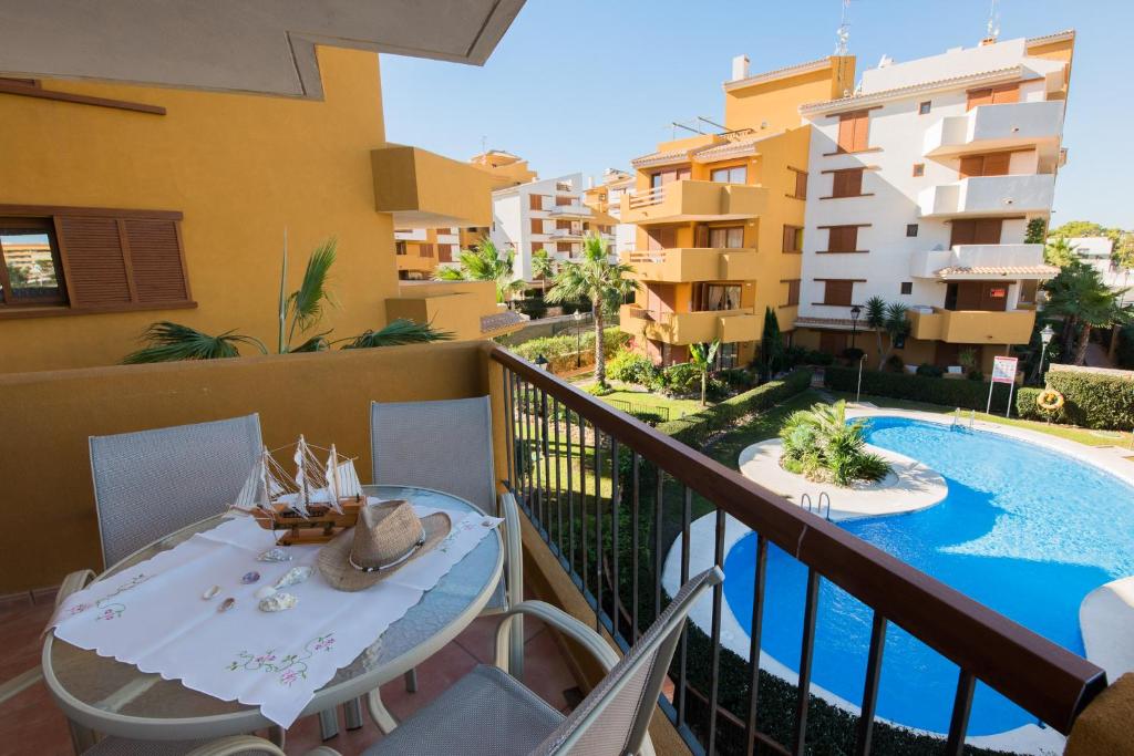 een balkon met een tafel en een zwembad bij Apartament PARAISO DEL SOL in Torrevieja