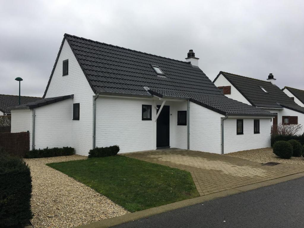 una casa bianca con tetto nero di Nieuwendamme 130 vakantiewoning voor 6 personen a Nieuwpoort