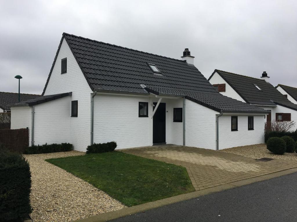 a white house with a black roof at Nieuwendamme 130 vakantiewoning voor 6 personen in Nieuwpoort