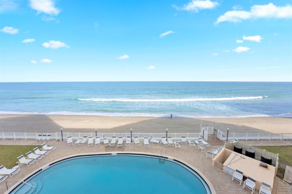 a view of the beach and a swimming pool and the ocean at Paradise Beach Club - Oceanfront and Penthouse in Satellite Beach