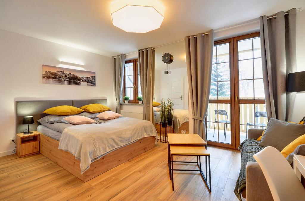 ein Schlafzimmer mit einem Bett und einem Sofa in der Unterkunft Apartament Królewski in Karpacz