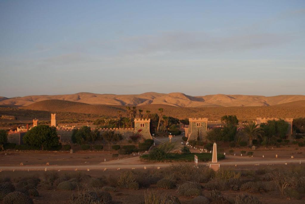 een stad in de woestijn met bergen op de achtergrond bij Complexe touristique FORT BOU-JERIF in Guelmim