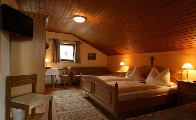 ein Schlafzimmer mit einem großen Bett und einer Holzdecke in der Unterkunft Haus Tschakert in Anger