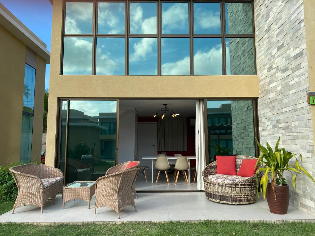 un patio avec des chaises et une table en face d'un bâtiment dans l'établissement Morada do Toque - TOQUINHA, à São Miguel dos Milagres