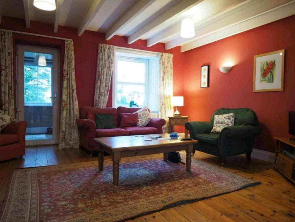 a living room with two couches and a coffee table at Barcloy Milk House in Kirkcudbright