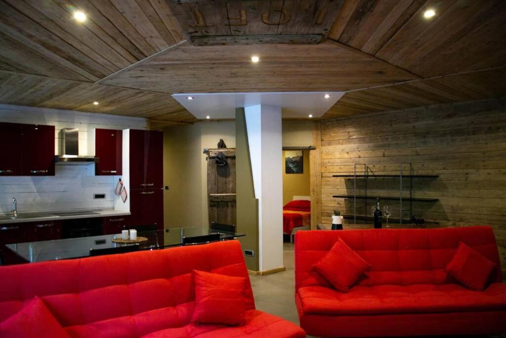 a living room with a red couch and a kitchen at LOFT nelle Valli in Pessinetto