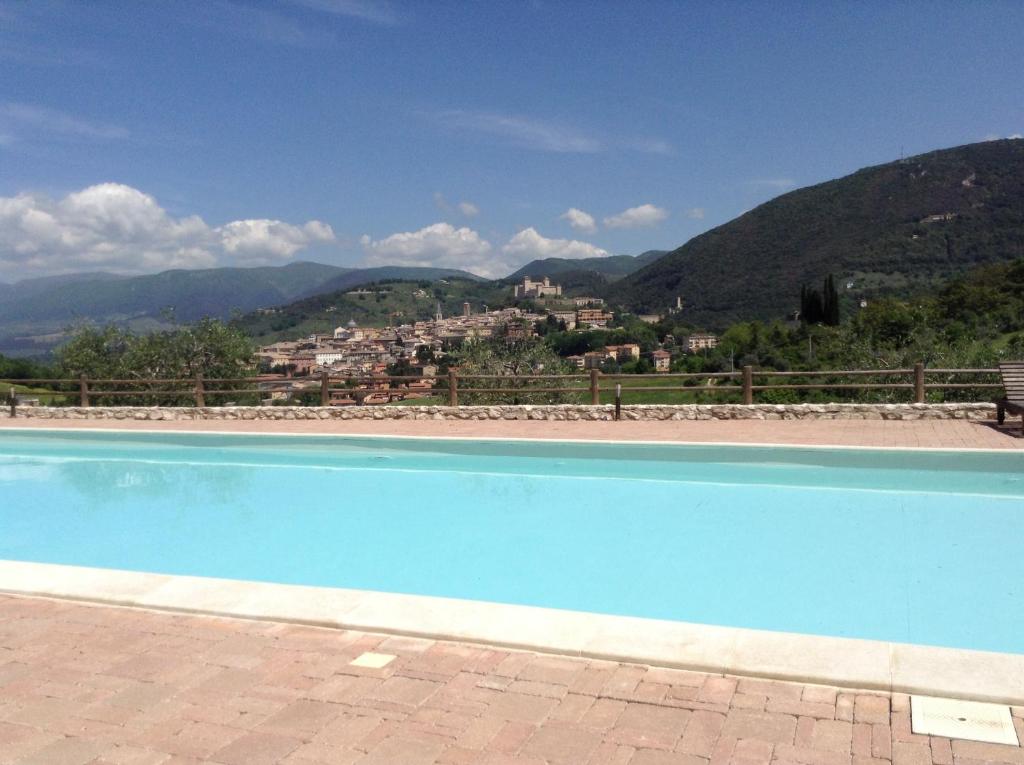 a blue swimming pool with a view of a mountain at Il Sogno in Spoleto