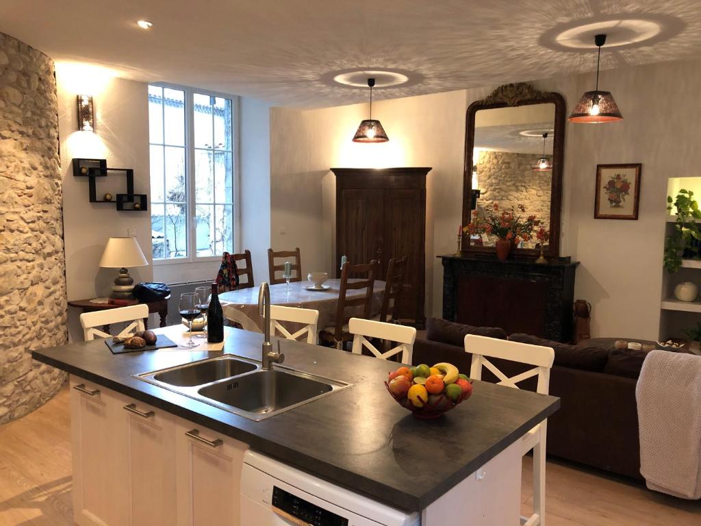cocina con fregadero y sala de estar. en Gite Joséphine dans une tour médiévale - Carcassonne en Saint-Hilaire